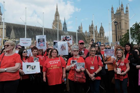 Protestors assembled at Parliament Square carrying signs and wearing red t-shirts. Photo by Joao Daniel Pereira/Sipa USA via AP Images