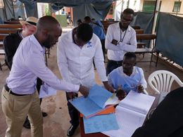 Physicians in Uganda review materials and discuss how to coordinate medicalcare for patients.