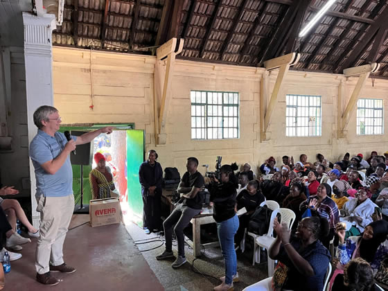 Dr. Keith Fowke speaking to an auditorium of community members in Kenya.