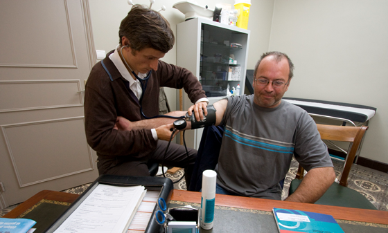 male doctor testing blood pressure of man
