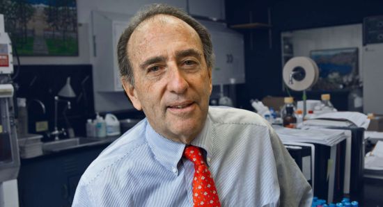 Jay Levy poses in red tie in laboratory. Photo by Susan Merrell