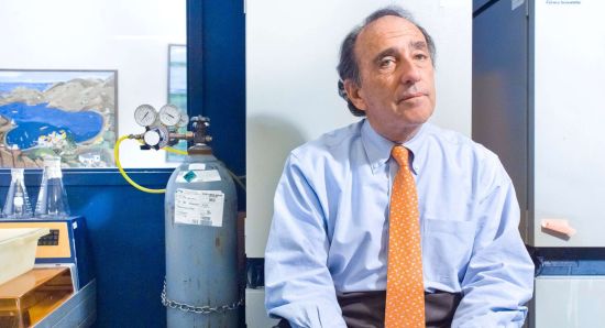 Jay Levy sits stylishly in bright yellow tie next to a helium tank